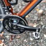 Naprawa napędu roweru gravelowego. Widoczny mechanizm korbowy GRX, łańcuch i pedał.