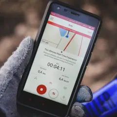 Rękawiczka trzyma smartfon z aplikacją do śledzenia aktywności. Szukasz co zamiast Endomondo? Ta aplikacja pokazuje dystans 0,4 km i średnią prędkość 6,4 km/h.