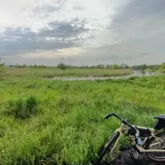 Rower na tle łąk i rzeki, gdzieś w okolicy najwyższego pasma Gór Świętokrzyskich.