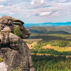 Majestatyczne, bledne skały górują nad zieloną doliną pełną lasów i pól. Widok zapiera dech w piersiach.