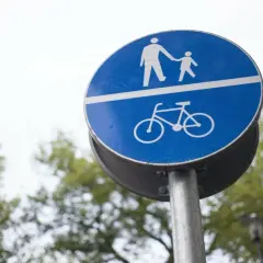 Znak C13 informuje o drodze dla pieszych i rowerzystów. Górna część znaku przedstawia idącego dorosłego z dzieckiem, a dolna rower.