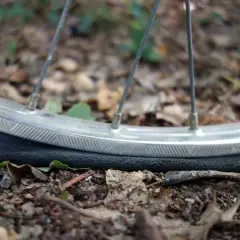 Płaska opona rowerowa leży na ziemi. Dowiedz się, jak napompować rower kompresorem, aby uniknąć takich sytuacji.