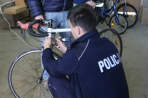 Policjant sprawdza rower, by ustalić, jak sprawdzić czy rower nie jest kradziony.