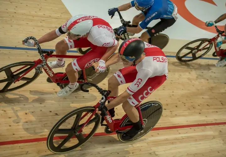 Kolarze w biało-czerwonych strojach walczą na torze. Emocje wyścigu keirin, madison i omnium widać w ich skupieniu i determinacji.