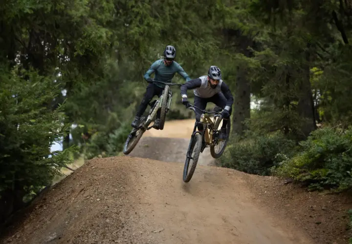 Dwóch rowerzystów w powietrzu na trasie zjazdowej. To właśnie **enduro co to** za sport, adrenalina i wolność!