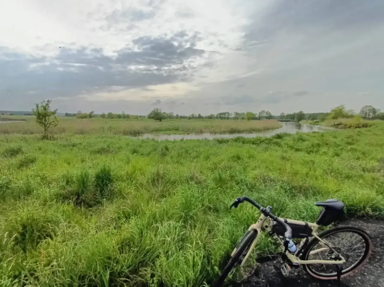 Rower na tle łąk i rzeki, gdzieś w okolicy najwyższego pasma Gór Świętokrzyskich.