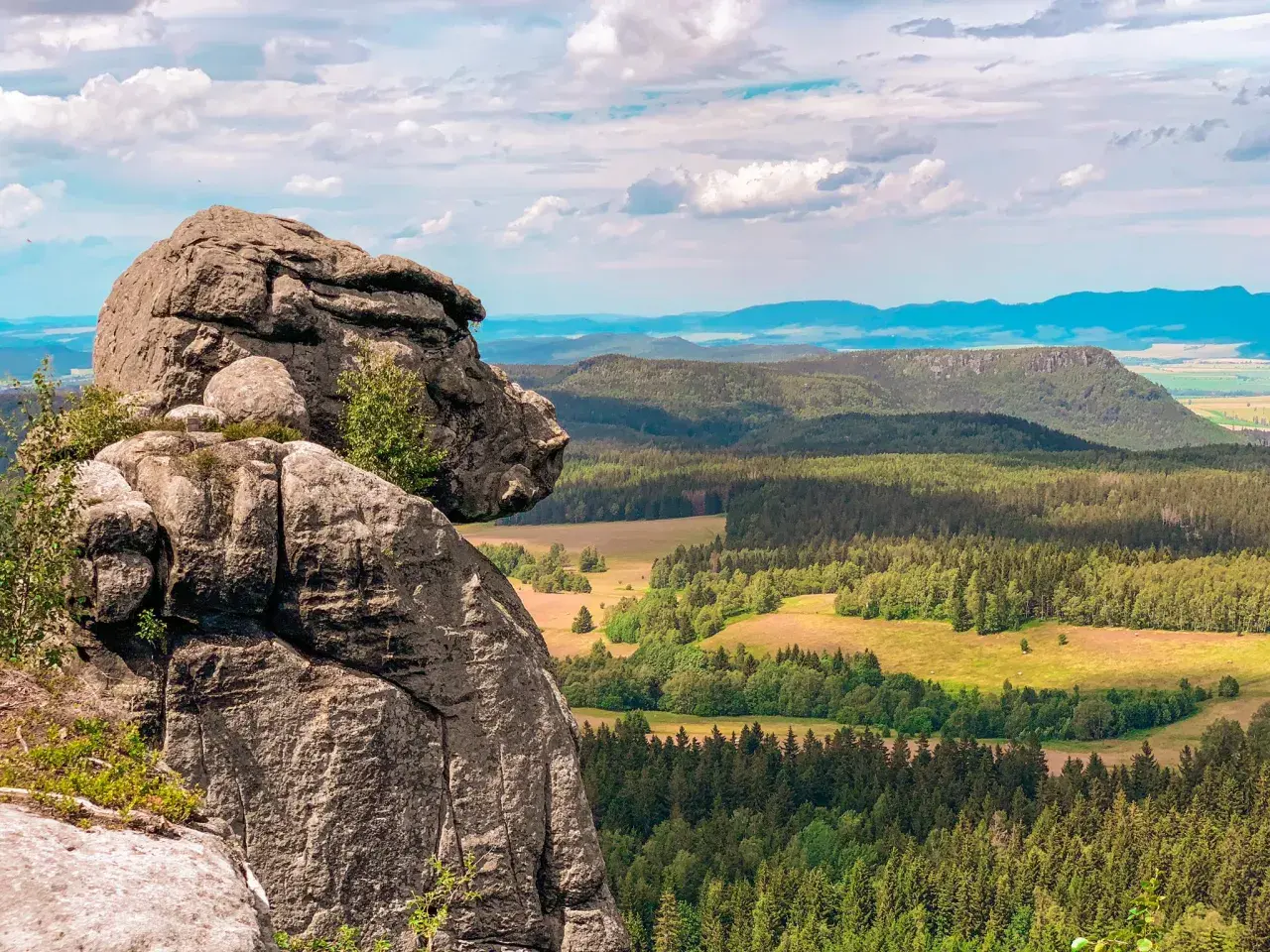 Majestatyczne, bledne skały górują nad zieloną doliną pełną lasów i pól. Widok zapiera dech w piersiach.