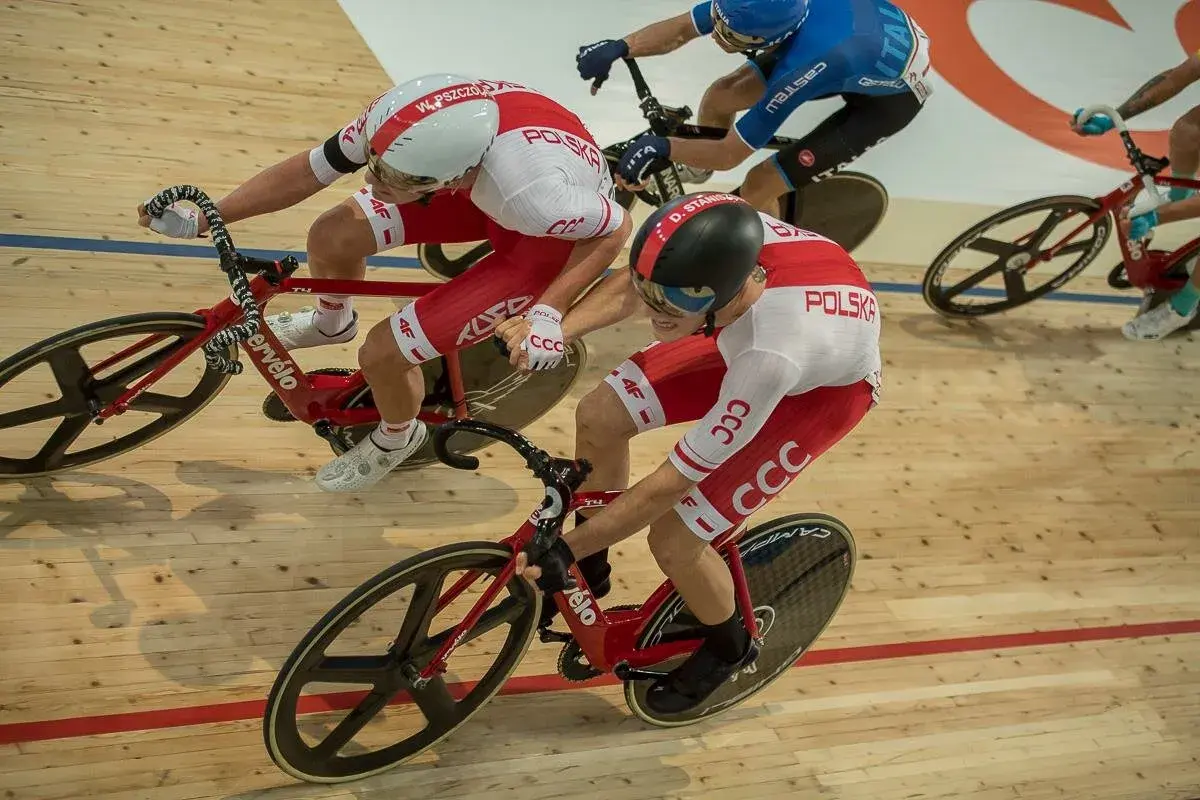 Kolarze w biało-czerwonych strojach walczą na torze. Emocje wyścigu keirin, madison i omnium widać w ich skupieniu i determinacji.
