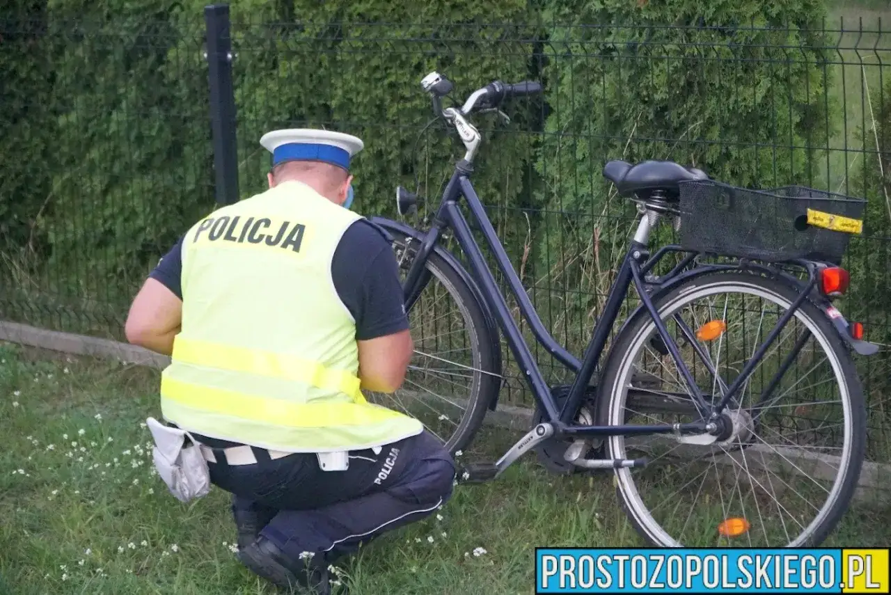 Policjant w kamizelce odblaskowej bada rower, który mógł należeć do pijanego na rowerze.