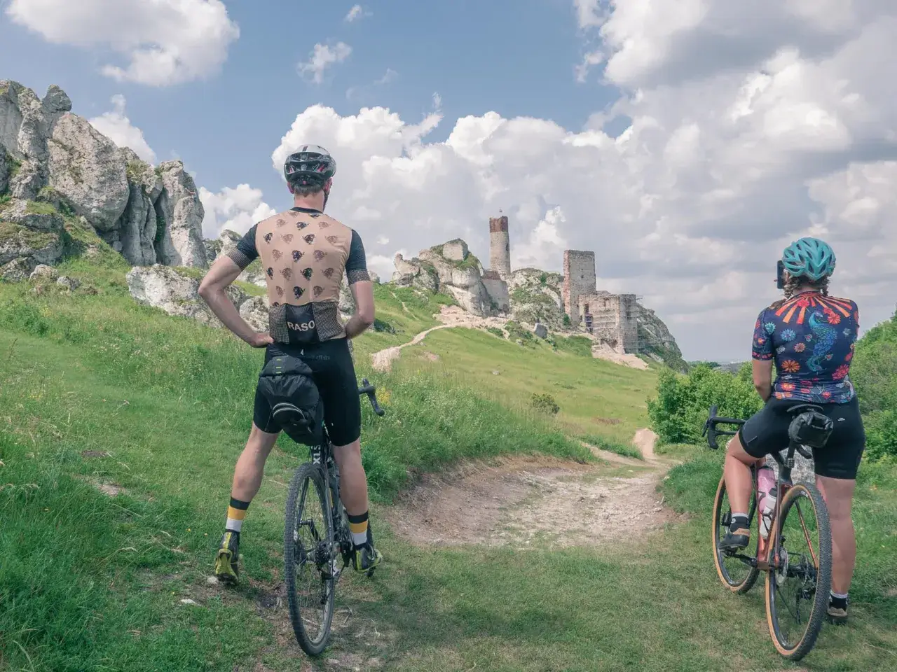 Rowerzyści podziwiają ruiny zamku na Szlaku Orlich Gniazd.