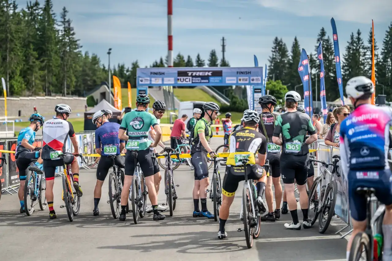 Kolarze gravelowe czekają na start. W tle baner Trek UCI Gravel World Series Poland.
