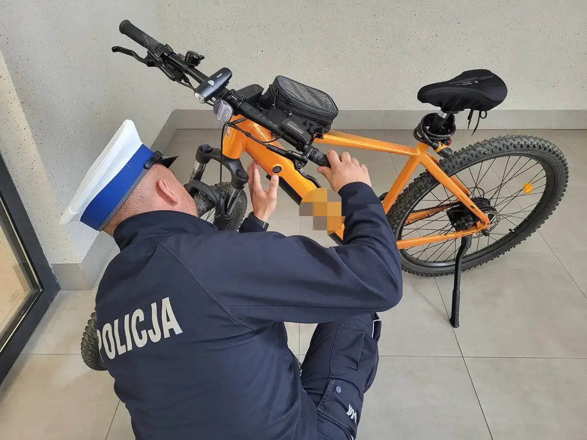 Policjant sprawdza rower elektryczny, zastanawiając się, czy na rower elektryczny trzeba mieć prawo jazdy.